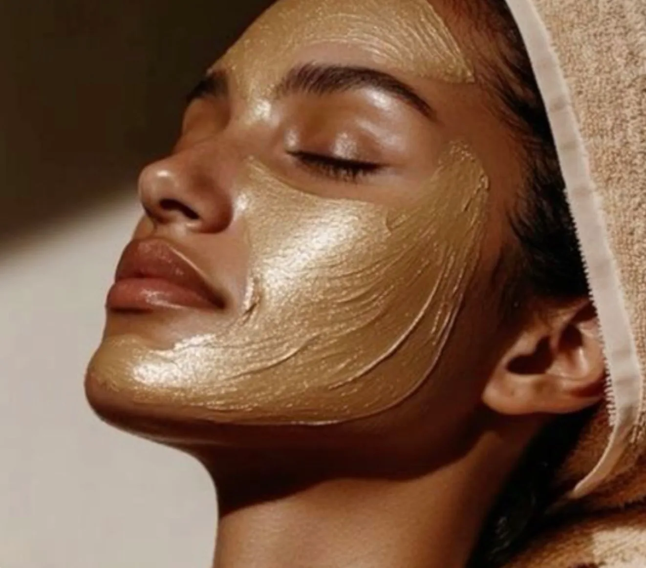 A client enjoying a customized Level 2 facial treatment with a golden mask applied to their skin.